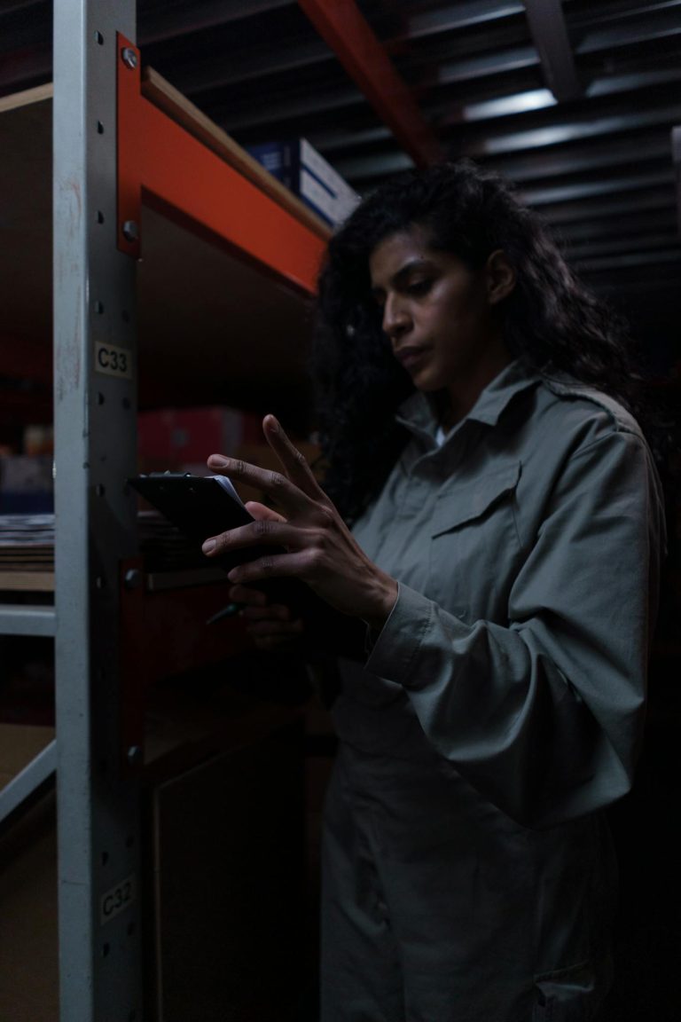 A dedicated female warehouse worker reviews inventory on a tablet.